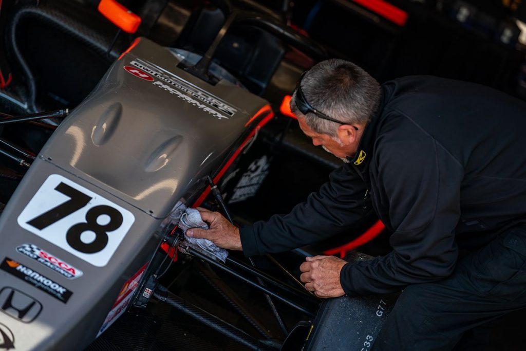 Man cleaning Crosslink Kiwi Motorsport formula car