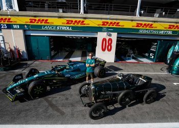 Sebastian Vettel standing between AMR22 Formula 1 car and 1922 Aston Martin TT1 Green Pea