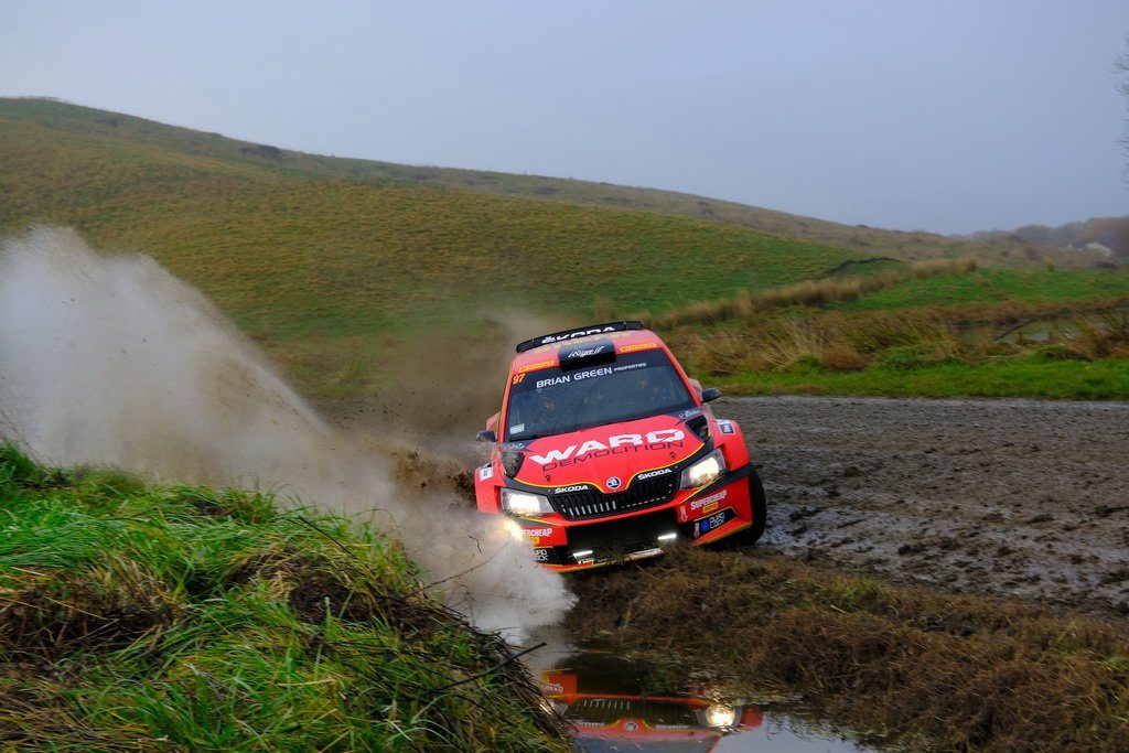 Shane van Gisbergen's Skoda Fabia R5 sliding around gravel corner hitting puddle front