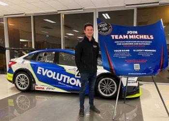 Jordan Michels standing in front of race car at Team Michels launch event