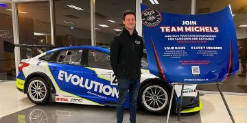 Jordan Michels standing in front of race car at Team Michels launch event