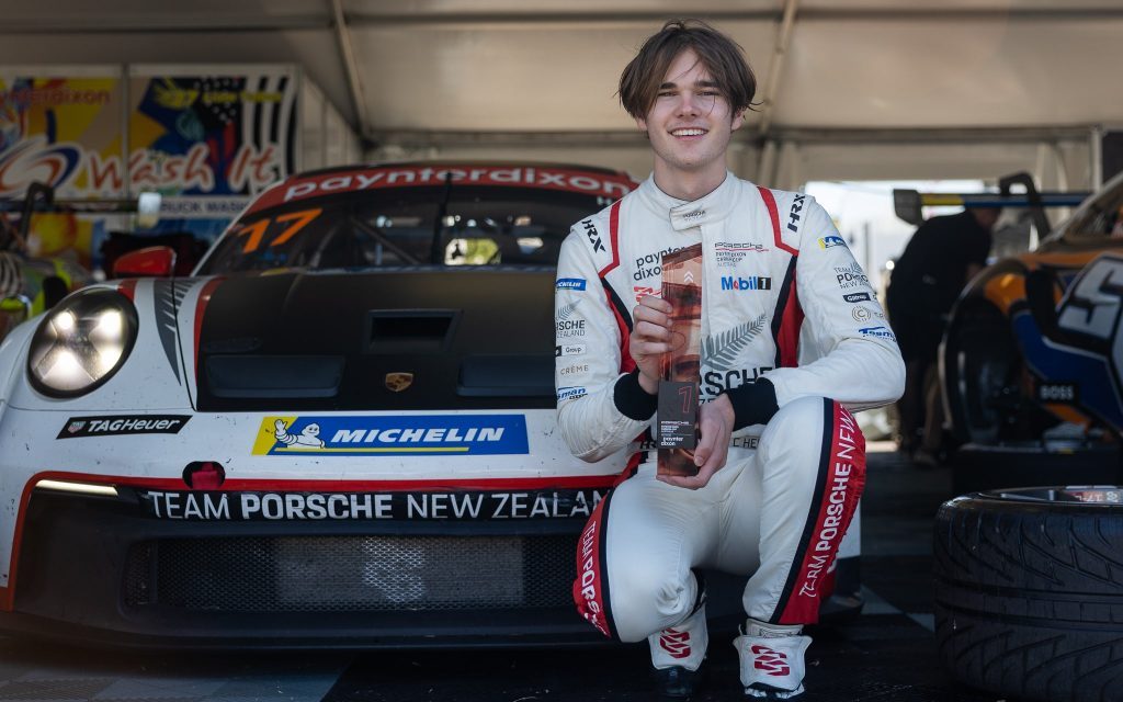 Callum Hedge standing in front of Porsche 911 Cup Car with Townsville Carrera Cup trophy