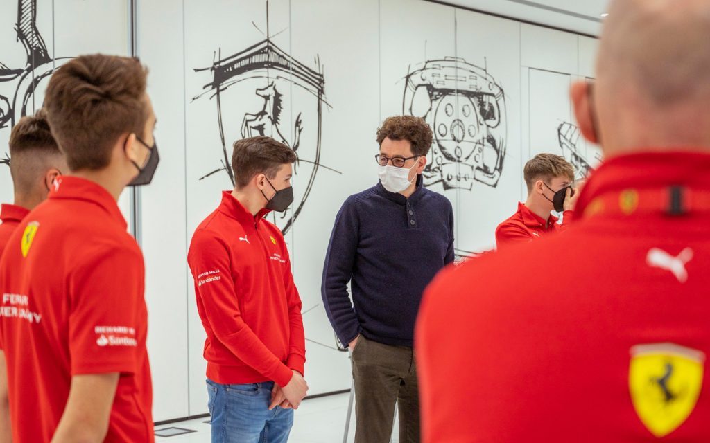 Mattia Binotto standing with Ferrari Driver Academy students