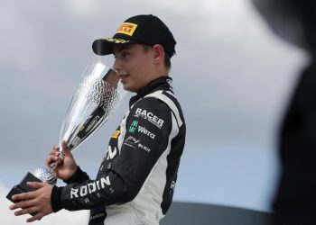 Louis Sharp standing on podium with third place trophy at Thruxton