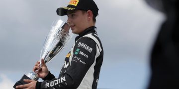 Louis Sharp standing on podium with third place trophy at Thruxton