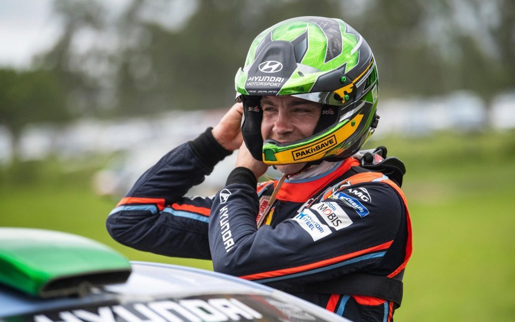 Hayden Paddon putting on race helmet