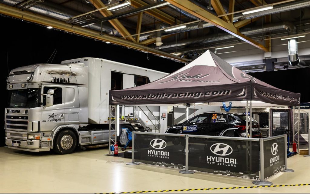 Hayden Paddon's Hyundai i20 N Rally2 WRC2 car being prepared next to Scania truck