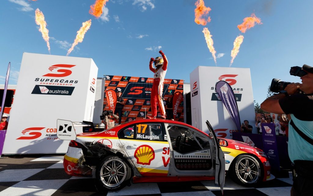 Scott McLaughlin celebrating 2018 Supercars championship win standing on roof of Ford Falcon FG X