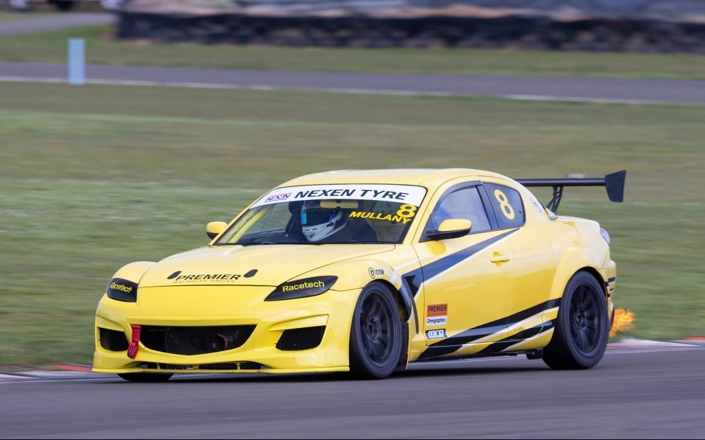 Flynn Mullany's Mazda RX8 racing on track with flame