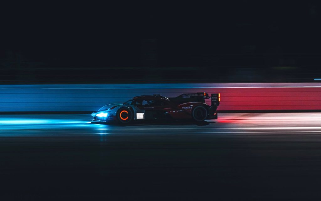 Porsche 963 LMDh racing on track at night
