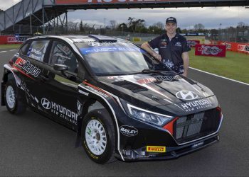 Hayden Paddon standing next to Hyundai i20 Rally2 car with Repco livery at Pukekohe