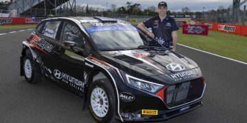 Hayden Paddon standing next to Hyundai i20 Rally2 car with Repco livery at Pukekohe