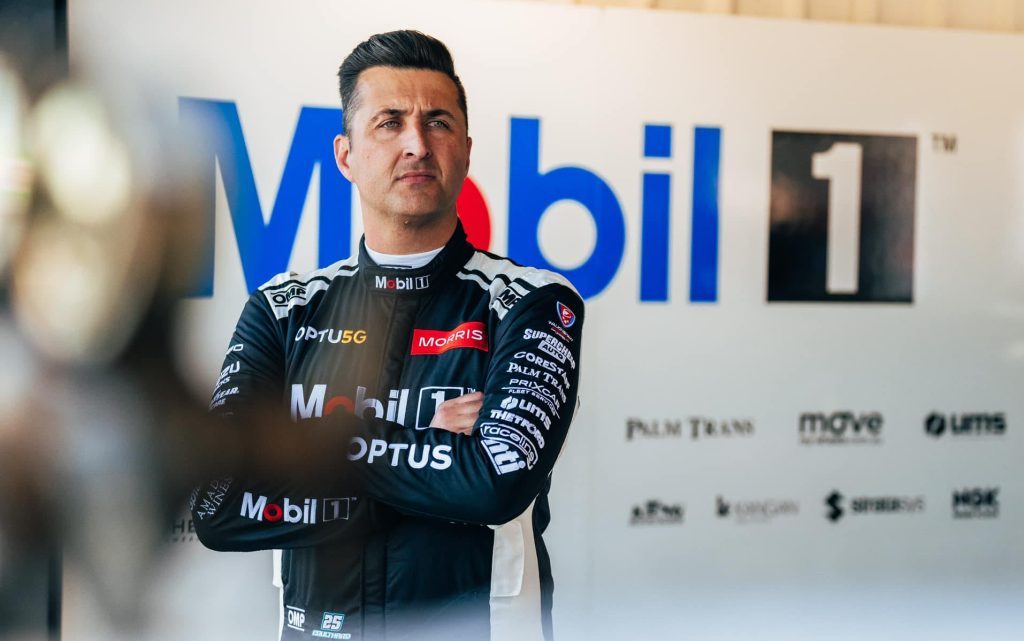 Fabian Coulthard standing with arms crossed in race suit