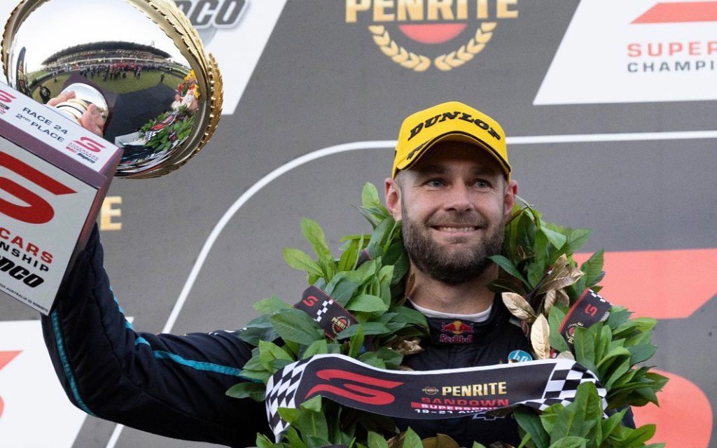 Shane van Gisbergen holding up trophy on Supercars podium