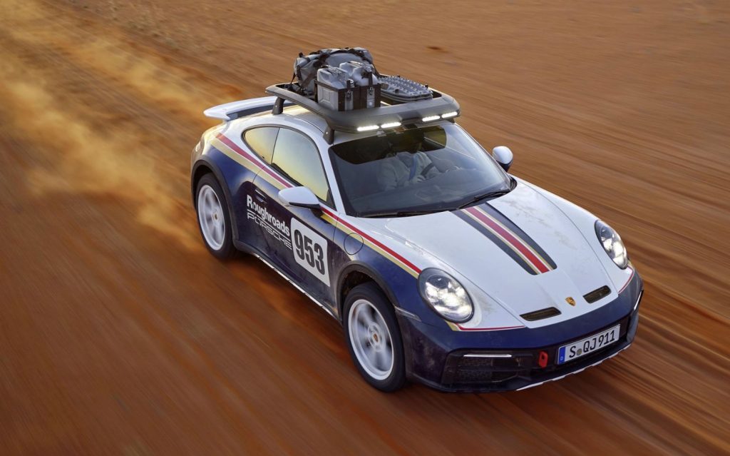 Porsche 911 Dakar driving off-road front three quarter view high angle