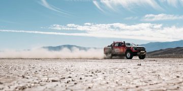 Ford Ranger Raptor Baja race truck driving at speed front three quarter view