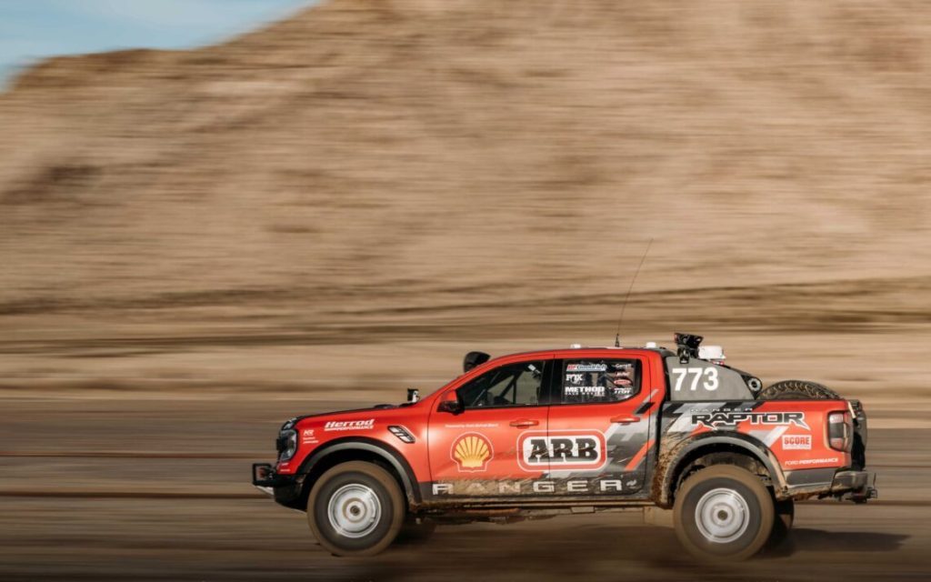 Ford Ranger Raptor Baja race truck driving at speed side view