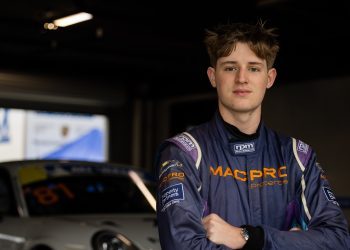 Tom McLennan standing in front of Porsche 911 race car