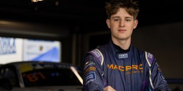 Tom McLennan standing in front of Porsche 911 race car