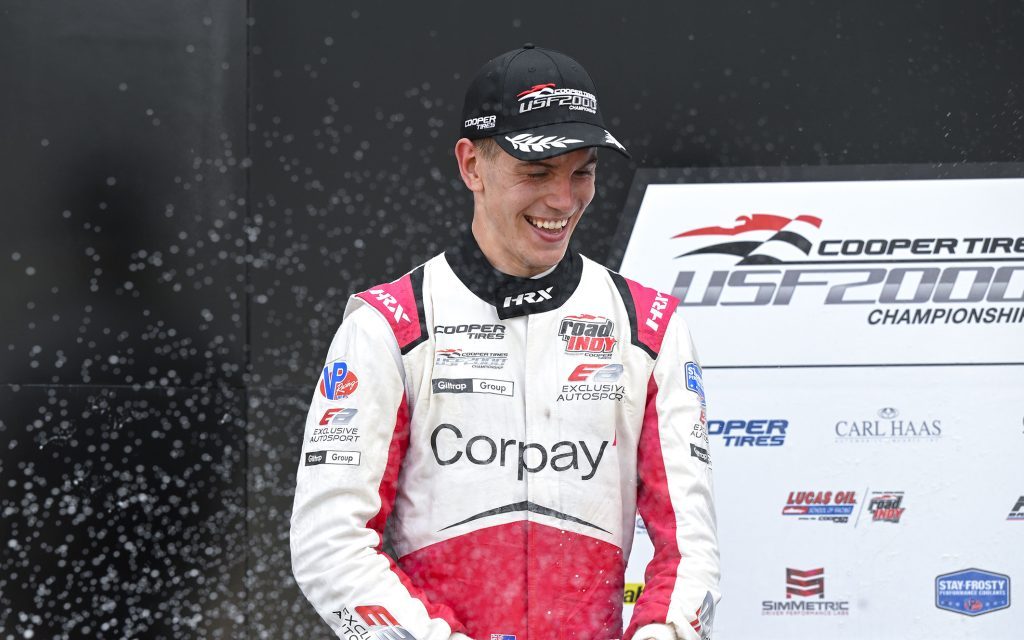 Billy Frazer celebrating on podium with champagne