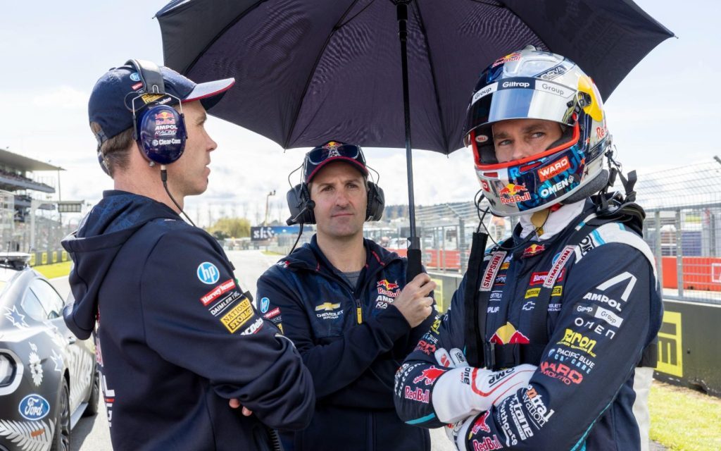 Jamie Whincup holding umbrella over Shane van Gisbergen