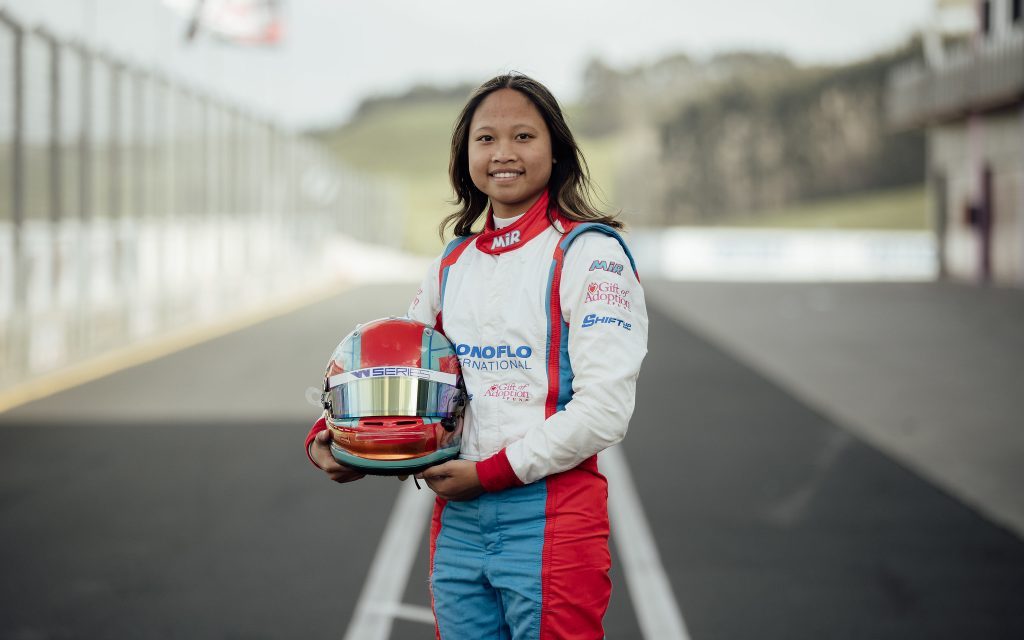 Chloe Chambers standing in pit lane with race helmet