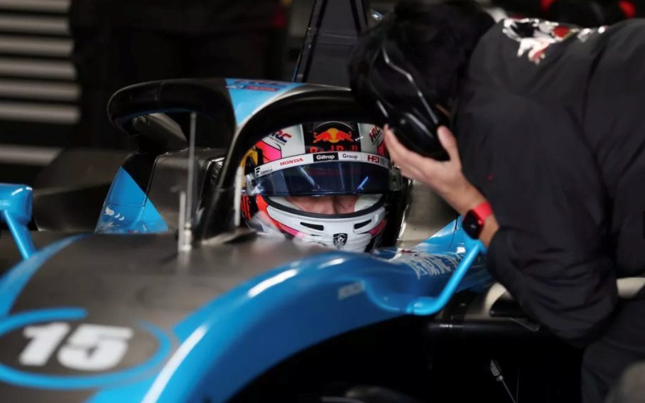 Liam Lawson sitting in Super Formula car in pit garage