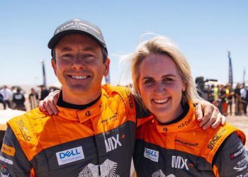 Tanner Foust and Emma Gilmour standing with arms around each other