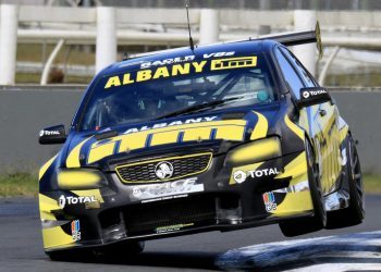 Holden Commodore V8 Touring Car racing over curb