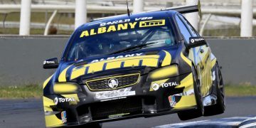 Holden Commodore V8 Touring Car racing over curb