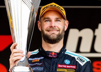 Shane van Gisbergen holding up winning trophy