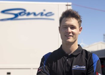 Ronan Murphy standing in front of Sonic Racing trailer