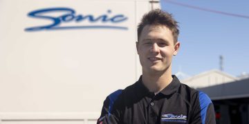 Ronan Murphy standing in front of Sonic Racing trailer