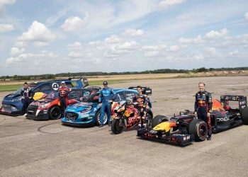 Liam Lawson standing with F1 car next to MotoGP bike, WRC rally car, Rallycross car and Ford E-Transit Supervan