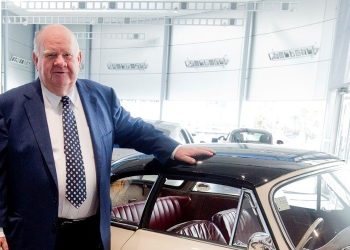 Sir Colin Giltrap standing with hand on car